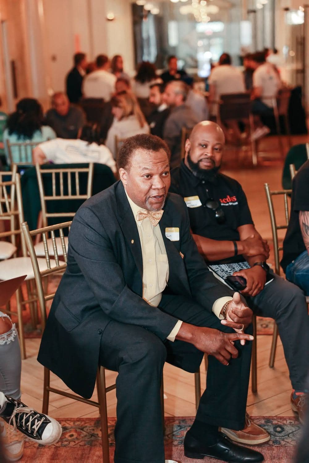 Two men seated in conversation at a Commonwealth Justice Coalition gathering