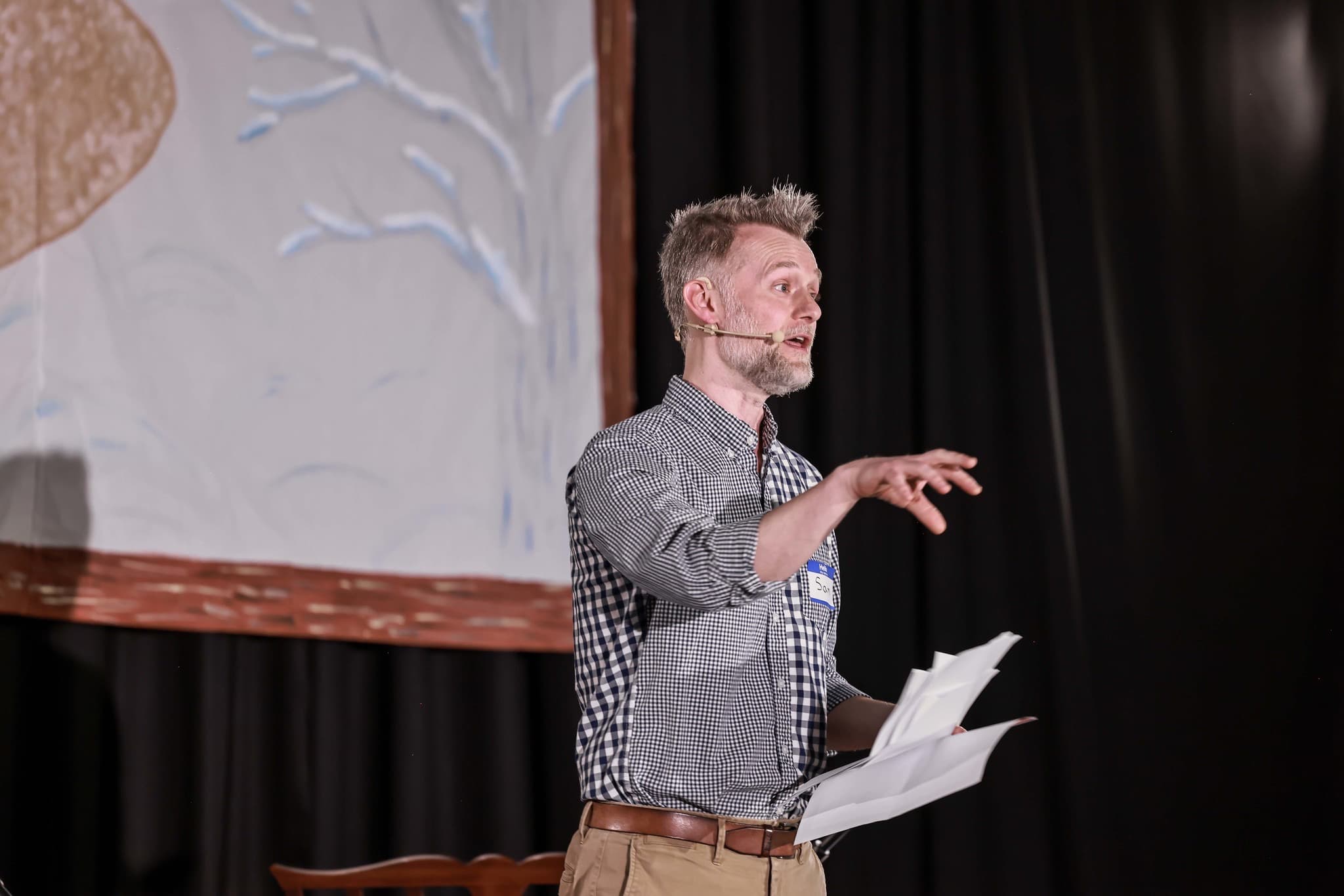 Sam Heath speaking on stage at a TEDx event